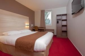 a hotel room with a large bed and a flat screen tv at Ekho Hotel Grenoble Nord Saint Egrève in Saint-Égrève
