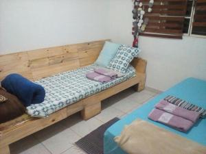 a wooden bench with pillows on it in a room at Thaumatropio Guest Home in Campo Grande