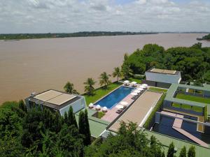 an aerial view of a house with a swimming pool next to a river at The Bale Phnom Penh by LifestyleRetreats in Phnom Penh