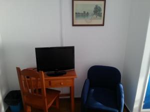 阿瓜爾達的住宿－濱海旅館，客房设有一张桌子、一台电视和一把椅子