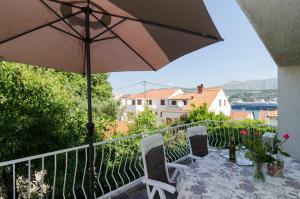 a balcony with a table and an umbrella at Apartment Veve in Dubrovnik