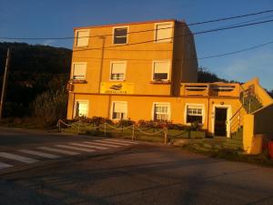 阿瓜爾達的住宿－濱海旅館，街道边的黄色建筑
