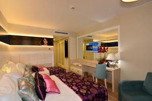 a bedroom with a bed and a desk and a sink at Azura Deluxe Resort & Spa - Ultra All Inclusive in Avsallar