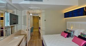 a hotel room with a bed with pink pillows at Azura Deluxe Resort & Spa - Ultra All Inclusive in Avsallar