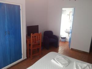 阿瓜爾達的住宿－濱海旅館，一间卧室配有一张床、一张桌子和一把椅子
