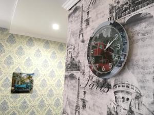 a clock on the side of a wall with graffiti at Apartament Berloga55 on 10 Let Oktiabria in Omsk