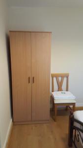 a wooden cabinet in a room with a table at Cedars House Hotel in Croydon