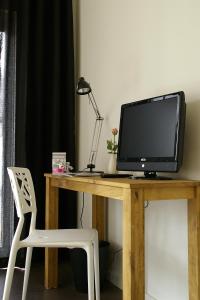 a desk with a computer monitor and a white chair at Rosa Arvensis in Lottum