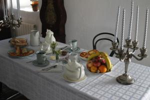 a table with a white table cloth with a bowl of fruit at Casona de Treviño in Cosgaya