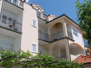 a large white building with a balcony at Pansion Dragica in Rab