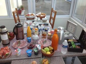 a table with a bunch of food and drinks on it at Chambre d'hotes Le Hamel in Le Hamel