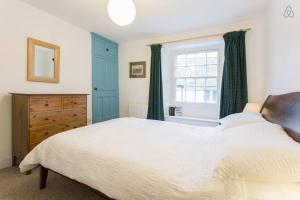 a bedroom with a large bed and a window at Fisherman's Cottage in Saint Mawes