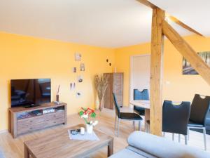 a living room with a couch and a tv and a table at Ferienwohnung Knoth in Altenburg