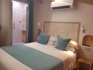 1 dormitorio con 1 cama grande con almohadas azules en My Rooms Ciutadella Adults Only by My Rooms Hotels, en Ciutadella