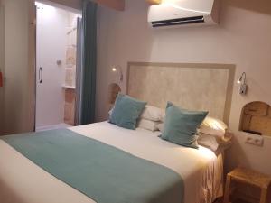 una camera da letto con un grande letto con cuscini blu di My Rooms Ciutadella Adults Only by My Rooms Hotels a Ciutadella