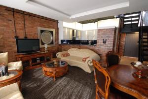a living room with a couch and a tv at Manhattan Apartments in Cape Town