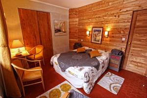 um quarto com uma cama, uma mesa e uma secretária em La Maison Rapin em Valloire