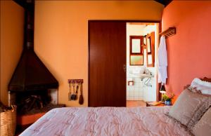 a bedroom with a bed and a fireplace at Pousada Bicho do Mato in Gonçalves
