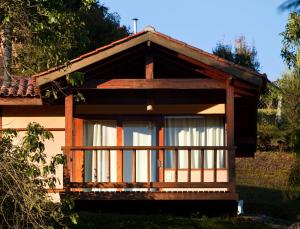 une petite maison avec une terrasse couverte et une fenêtre dans l'établissement Pousada Bicho do Mato, à Gonçalves