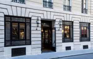 a building with windows and doors on a street at Hôtel La Tamise - Esprit de France in Paris