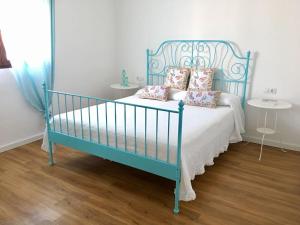 Una cama azul con almohadas en el dormitorio en Zone23 Home, en Porís de Abona
