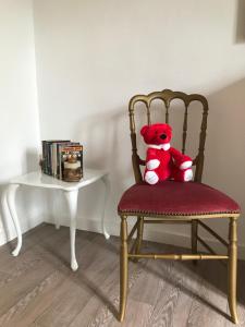 a teddy bear sitting on a chair next to a table at Fenêtres sur Mer Arromanches in Arromanches-les-Bains