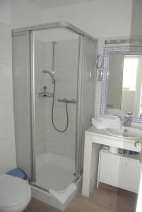 a bathroom with a shower and a toilet and a sink at Hotel Rosenhof in Kühlungsborn