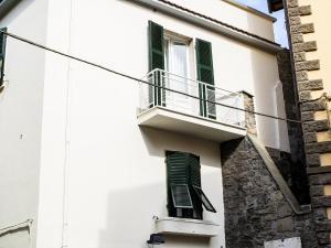 um edifício branco com persianas verdes e uma varanda em Guest House S.Caterina em Viterbo