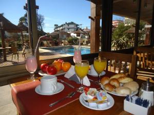 a table with food and drinks on a table with a pool at Alpemar Apart Hotel & Spa in Villa Gesell
