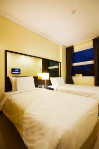 a hotel room with two beds and a window at Go Hotels Tacloban in Tacloban