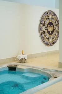 een blauw zwembad in een kamer met een bord aan de muur bij Theoxenia Palace in Athene