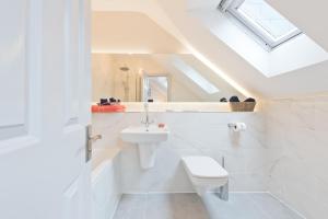 a white bathroom with a toilet and a sink at Exclusive City Centre Apartment in Dublin +31 photos