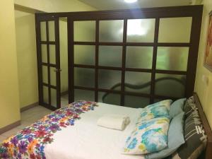 a bed with a wooden headboard with flowers on it at Leons Den is a long term accomodation of atleast 1 month stay in Manila +9 photos