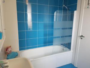 エル・ベルゲルにあるFerienvermietung Davidの青いタイル張りのバスルーム(バスタブ、シンク付)