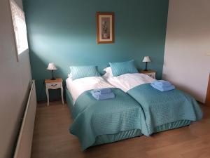 a bedroom with a bed and two tables with lamps at Lamb Inn Öngulsstadir in Akureyri