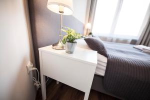 a bed with a lamp on top of it next to a window at Apartamenty Baszta in Gdańsk
