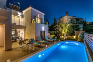 a villa with a swimming pool at night at Superior Villa Marina Mare with Sauna Hammam & Parking in Nea Kydonia