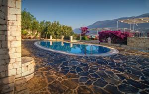 a swimming pool in a yard with a stone wall at Korsanada Hotel in Kaş +44 photos