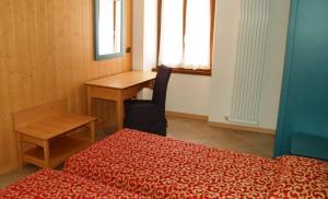 a room with a bed and a desk and a table at Residence Centrale in Dro