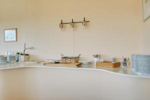 a white counter with plates and bowls on it at Hotel Sønderborg Garni in Sønderborg