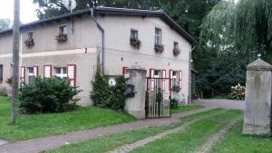 a white house with red windows and a gate at Ferienwohnung Siebmann in Neuruppin