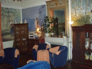sala de estar con sillas azules y chimenea en Chambres et Tables d'Hotes Les Breuils, en Mariol