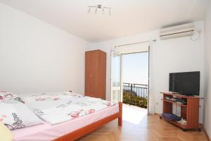 a bedroom with a bed and a flat screen tv at Apartments Beslema in Dubrovnik