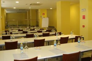 a classroom with tables and chairs with bottles of water on them at Hotel Palacio Congresos in Palencia