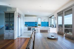 a kitchen with a wooden table and a kitchen with blue at Saltaire in Saint Andrews Beach