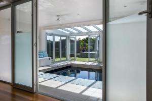 an open glass door leading to a swimming pool in a house at Saltaire in Saint Andrews Beach