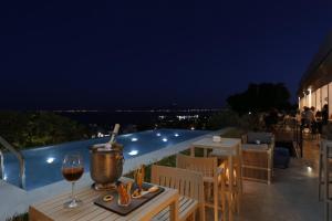 a table with a glass of wine next to a pool at Hotel Villa Didon Carthage in Carthage