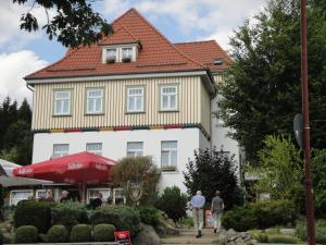 a large white building with a red roof at Gasthaus Brockenhėxe mit Restaurant & Café in Schierke