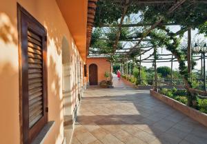a walkway in a building with a woman walking down it at Hotel Il Girasole in Anacapri