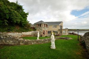 una casa con due statue di fronte a un muro di pietra di Barrow Lodge a Tralee